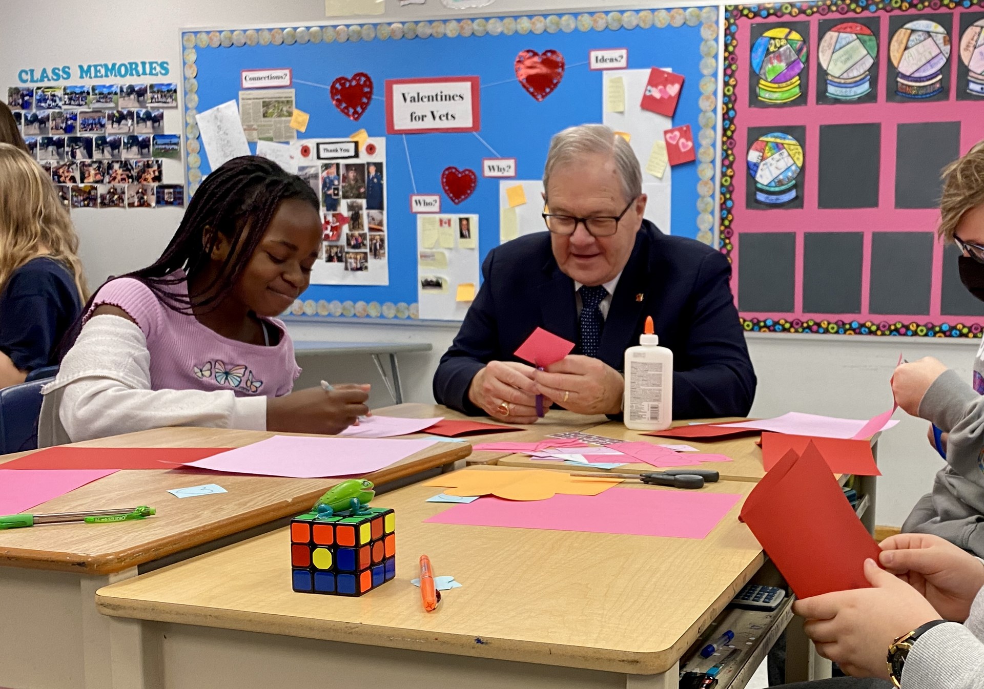 St. Martha student sitting with Hon. Lawrence MacAulay making Valentine's Day cards.