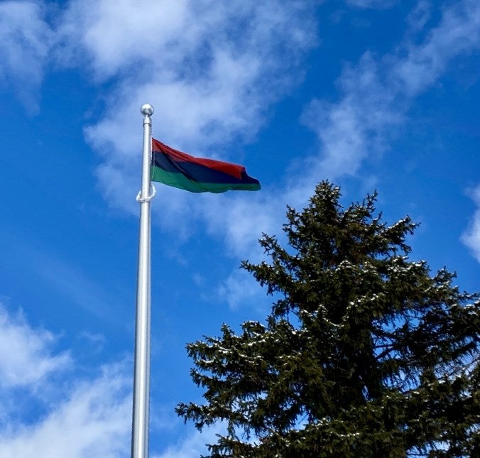 Pan African flag flying on a flagpole outside of the Board office.