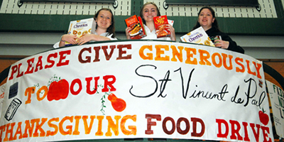 Students hold donations for food drive.jpg