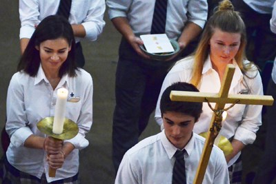 Student Mass recessional with candles and cross.jpg