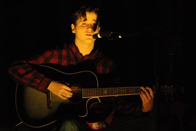 Student Quentin sings and plays guitar on the HC stage.jpg