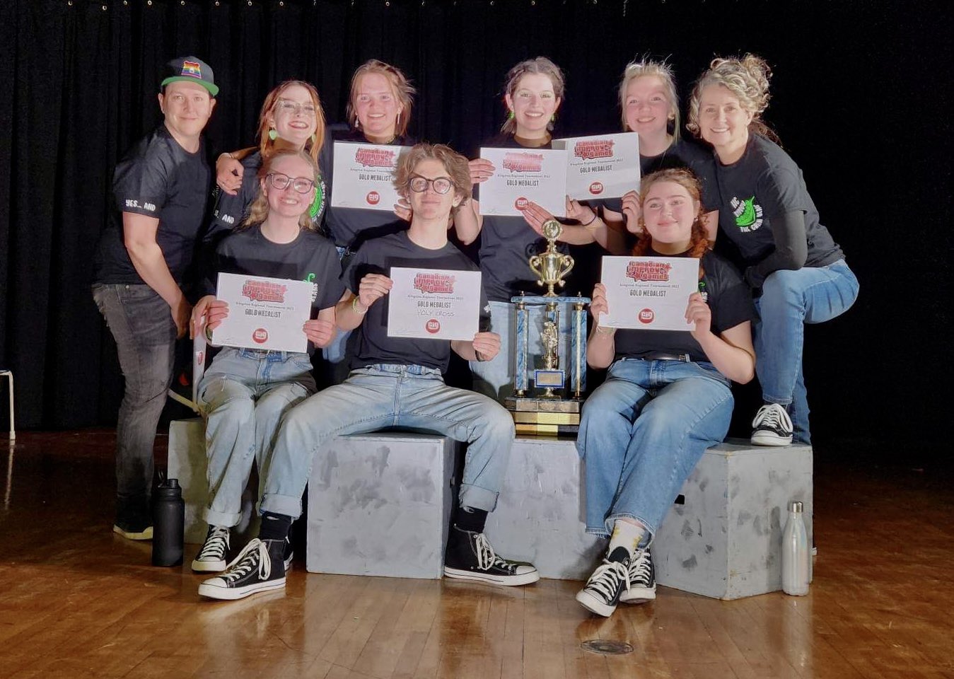 All eight Green Beans Improv Team pictured holding “Gold Medalist" certificates from the Canadian Improv Games.