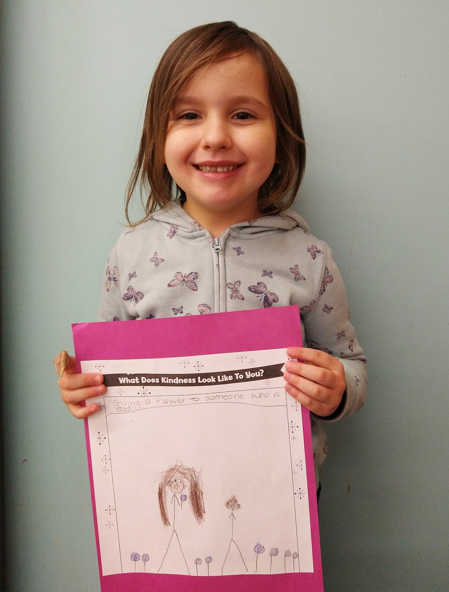 OLMC student holding her colouring submission.