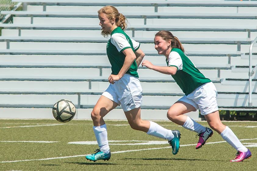 Girls running with soccer ball