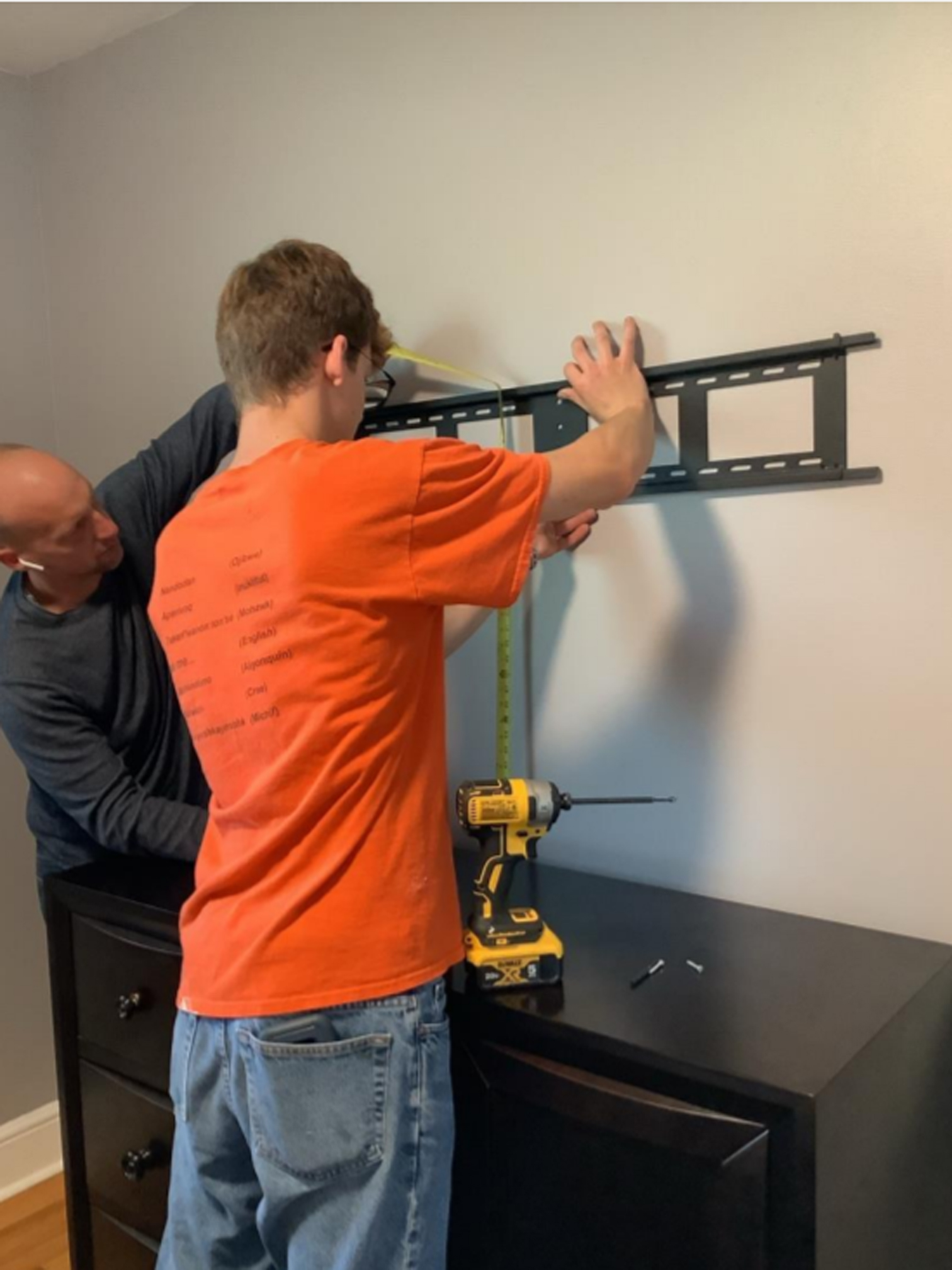 Student hanging a bracket on the wall